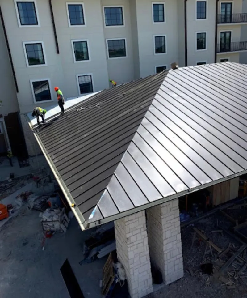 Crew installing standing seam metal roof panels on a commercial project in Downey